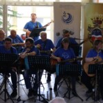 Városi Humánsegítő és Szociális Szolgálat | Galéria Zenélő zenészek gitárral a kezükben.