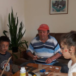 Városi Humánsegítő és Szociális Szolgálat | Galéria Asztalnál ülő emberek papírokat vágnak.