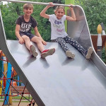 Városi Humánsegítő és Szociális Szolgálat | Napközis tábor a Családsegítőben Két fiatal csúszdázik.