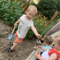 Egy kisfi&uacute; ny&uacute;jtja egy m&aacute;sik kisfi&uacute;nak a ki&aacute;sott hagym&aacute;t.