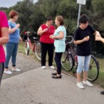 Emberek csoportk&eacute;pe egy eml&eacute;kműn&eacute;l.