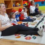 Városi Humánsegítő és Szociális Szolgálat | Mikulás várás a bölcsődében A gyerekek ülve várják a Mikulást.