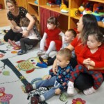 Városi Humánsegítő és Szociális Szolgálat | Mikulás várás a bölcsődében A gyerekek ülve várják a Mikulást.