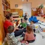 Városi Humánsegítő és Szociális Szolgálat | Sünikék a bölcsődében Csoportkép gyerekekről, akik a kisgyermeknevelő meséjét hallgatják.