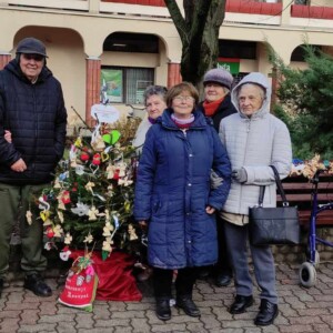 Városi Humánsegítő és Szociális Szolgálat | Galéria Idősek csoportképe egy Karácsonyfa mellett.
