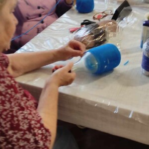 Városi Humánsegítő és Szociális Szolgálat | Galéria Idősek díszeket készítenek egy asztalnál.