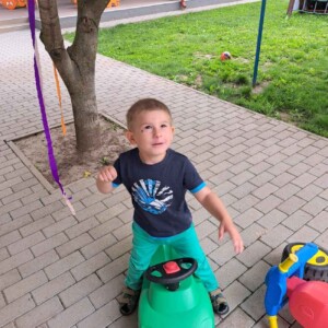 Városi Humánsegítő és Szociális Szolgálat | Gyermeknap a bölcsődében Játékmotorral játszó kisgyermek.