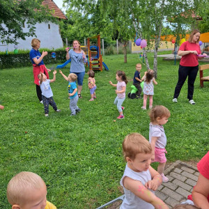 Egy csapat kisgyermek játszik a bölcsőde udvarán.