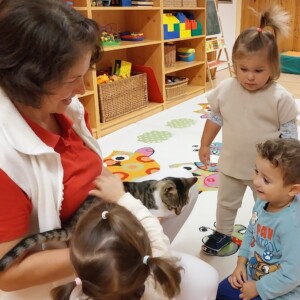 Városi Humánsegítő és Szociális Szolgálat | Állatok Világnapja a bölcsődében Cicával játszó gyermekek.