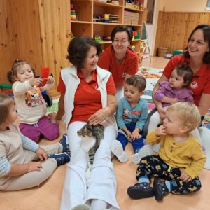 Városi Humánsegítő és Szociális Szolgálat | Állatok Világnapja a bölcsődében Cicával játszó gyermekek.