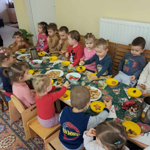 Gyerekek egy csoportja ül egy karácsonyi asztalnál.